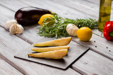 Slices of pear. Garlic and green herb. Fruit for special dish. Organic food ingredients on table.