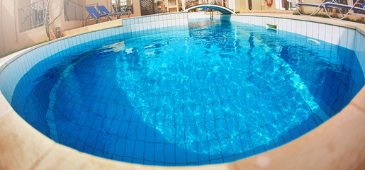 edge of the Swimming Pool. paving brick floor with blue shine water background