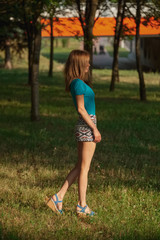 Pretty girl walks in park in shorts and shirt