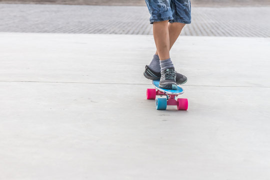 close up of boy's feet standing on modern short cruiser skateboa