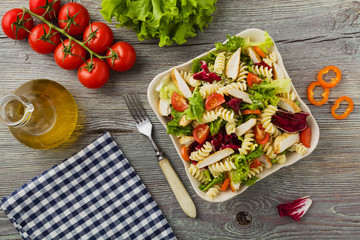 Noodle salad with green lettuce, tomatoes and roasted chicken.