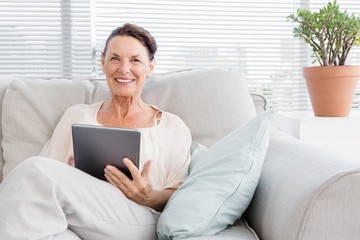 Portrait of happy mature woman holding digital tablet