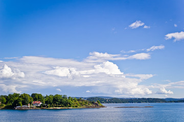 Вид с моря на Осло, солнечный день, голубое небо, море. the view of green place in Oslo in a sunny day