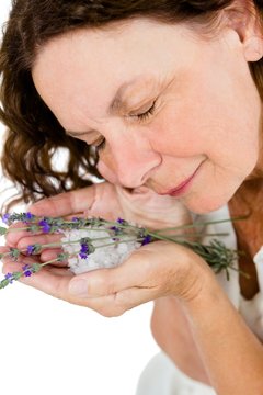 Smiling Mature Woman Smelling Flowers