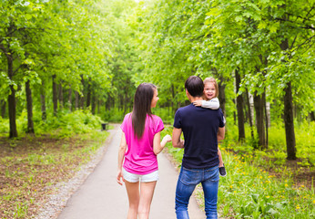 Fototapeta premium Happy mother, father and daughter in the park
