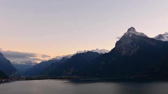 Magnificent panorama of mountains in central Switzerland. Setting sun painted the clouds in the grand color. Aerial view of the mountains and lake. Switzerland, Time Lapse