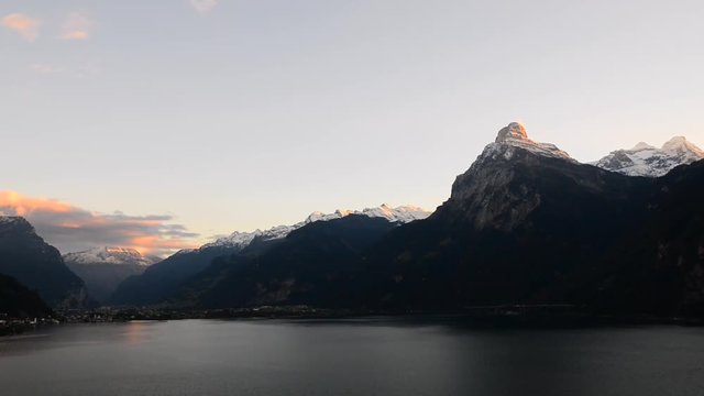 Magnificent panorama of mountains in central Switzerland. Setting sun painted the clouds in the grand color. Aerial view of the mountains and lake. Switzerland,  Time Lapse