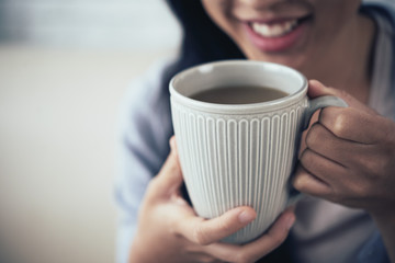 Close-up image of woman drinking big mug of coffee