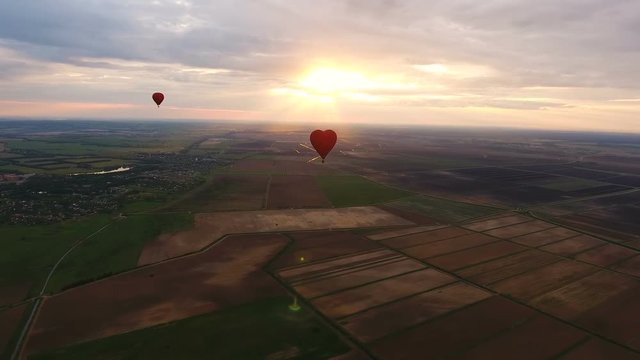 Hot air balloons in the sky over a field in the countryside.Aerial view:Hot air balloons in the sky over a field in the countryside in the beautiful sky and sunset.Aerostat fly in the countryside.