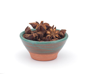 Star anise in a clay sauce-boat isolated on white background