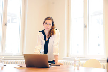  Bussinesfrau steht vor ihrem laptop im Büro