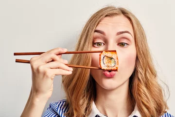 Selbstklebende Fototapeten Frau isst Sushi © tugolukof