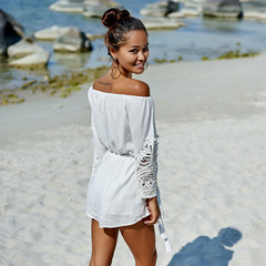Cute girl in dress walking on the beach - full body portrait