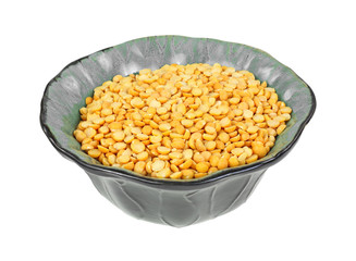 Yellow split peas in decorative bowl on a white background.