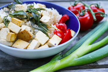 Veganes, vegetarische Mittagessen, Reis mit gebratenem Tofu in Kräuteröl, Salbei und Thymian mit frischen Tomaten