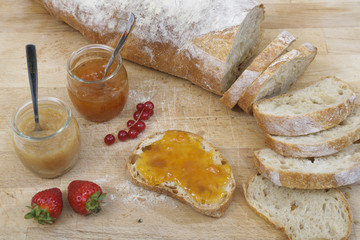 Bread, jam and fruits on a wooden cutting board