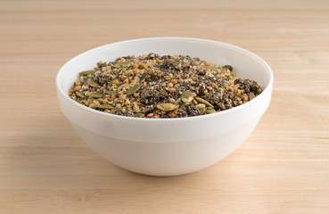 Chia cranberry and pumpkin seeds breakfast cereal in bowl on a wood table.