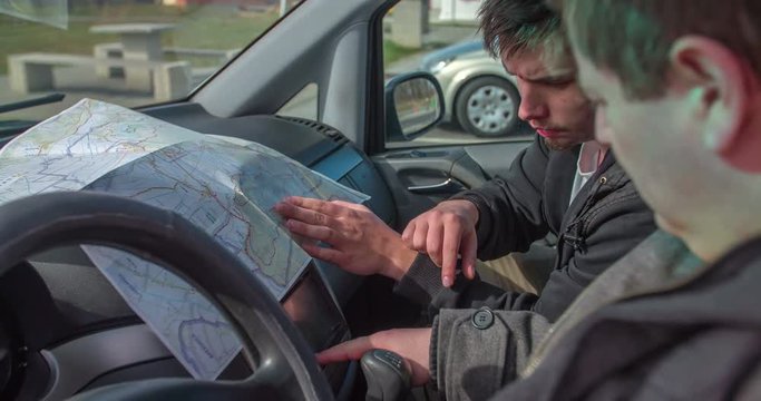 Two men are typing the directions in garmin. They are also checking the map. They're happy when they find the right address. The driver gives thumbs up.

