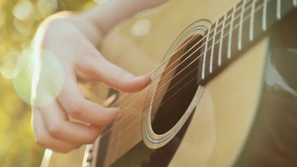 Beautiful young woman playing guitar on beach