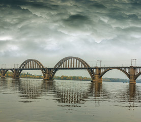 Fototapeta na wymiar bridge over a river at the dark wet weather