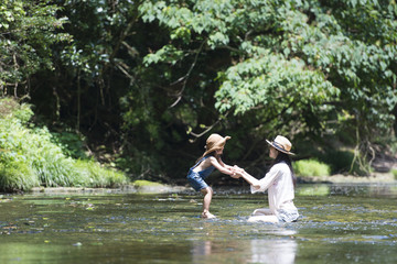 川で遊ぶ親子