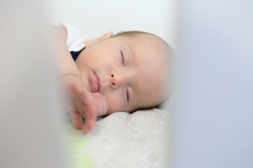 Baby boy sleeping in a crib 