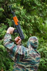 Soldier in camouflage with a gun in his hand, shallow DOF