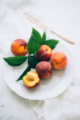 juicy peaches in a plate on a white background
