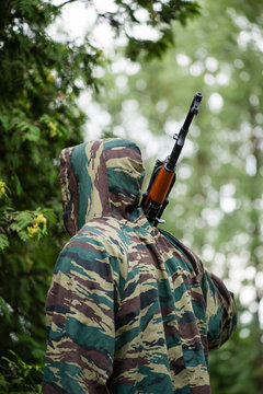 Soldier in camouflage with a gun in his hand , shallow DOF