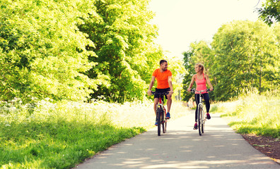 happy couple riding bicycle outdoors