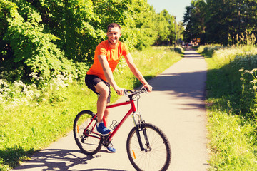 Plakat happy young man riding bicycle outdoors