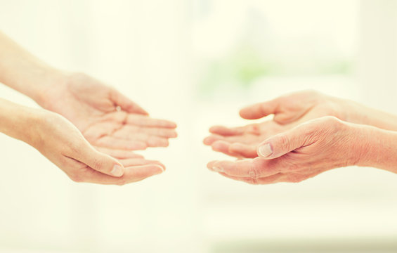 close up of senior and young woman hands
