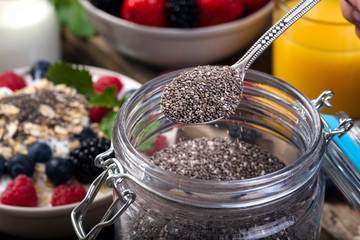 Spoon of chia. Bowl with berries.