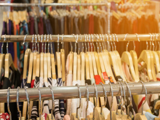 Clothes hang on rack shelf in clothing store