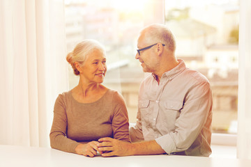 happy senior couple sitting on sofa at home
