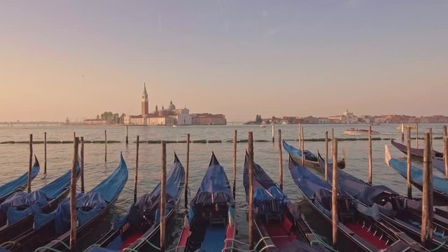 Drone aerial flying over parking gandolas with the bell tower of the Saint Giorgio Maggiore Church view.