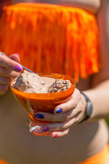 Young Sexy Hot Woman in Orange Bikini holding cup with Chocolate Ice-cream, Summer Day