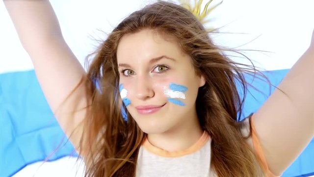 Girl waving Argentinian flag and smiling