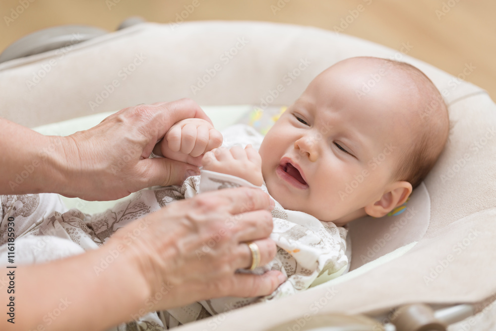 Wall mural Grandma playing with her newborn baby granddaughter