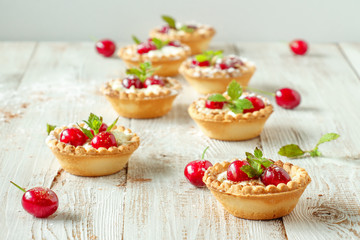 Tartlets with whipped cream and cherry.
