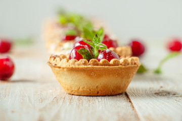 Tartlets with whipped cream and cherry.