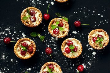 Tartlets with whipped cream and cherry.
