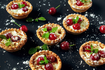 Tartlets with whipped cream and cherry.