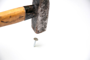 Studio isolated hammer hitting a nail