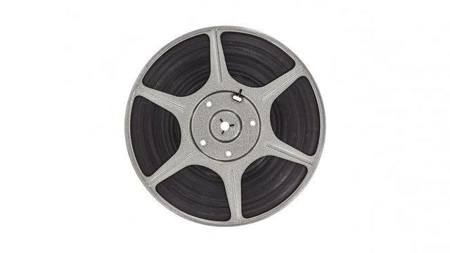 Spinning vintage 8 mm metal film reel isolated on white.