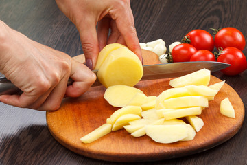 Cutting potato on a board