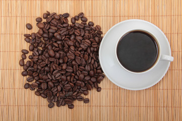 Coffee beans and a white cup on table