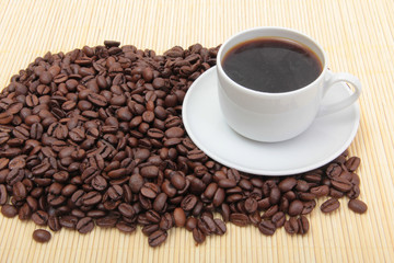 Coffee beans and a white cup on table