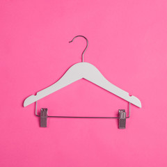 white wooden hanger for hanging clothes on pink background