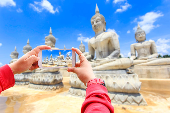 Smartphone photographing buddha statue and blue sky, Nakhon Si Thammarat Province, Thailand